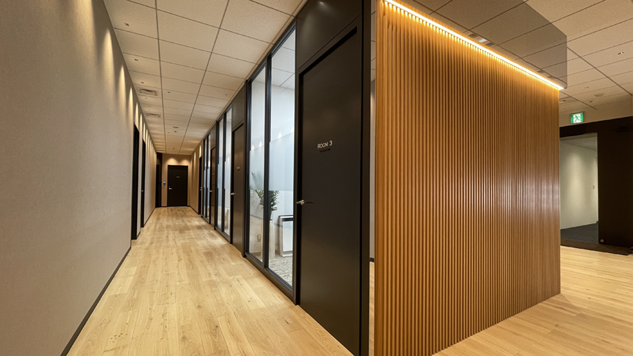 来客動線に配慮して設計されたオフィス内のダウンライドがきれいな廊下と会議室