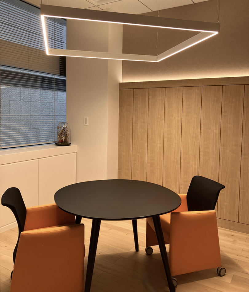 木目調の内装とデザイン照明が特徴のカジュアルな打ち合わせスペース