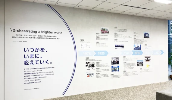 NECのパーパスである「Orchestrating a brighter world」と歴史年表を掲示したオフィス壁面。創立50周年の節目を迎え作成された。