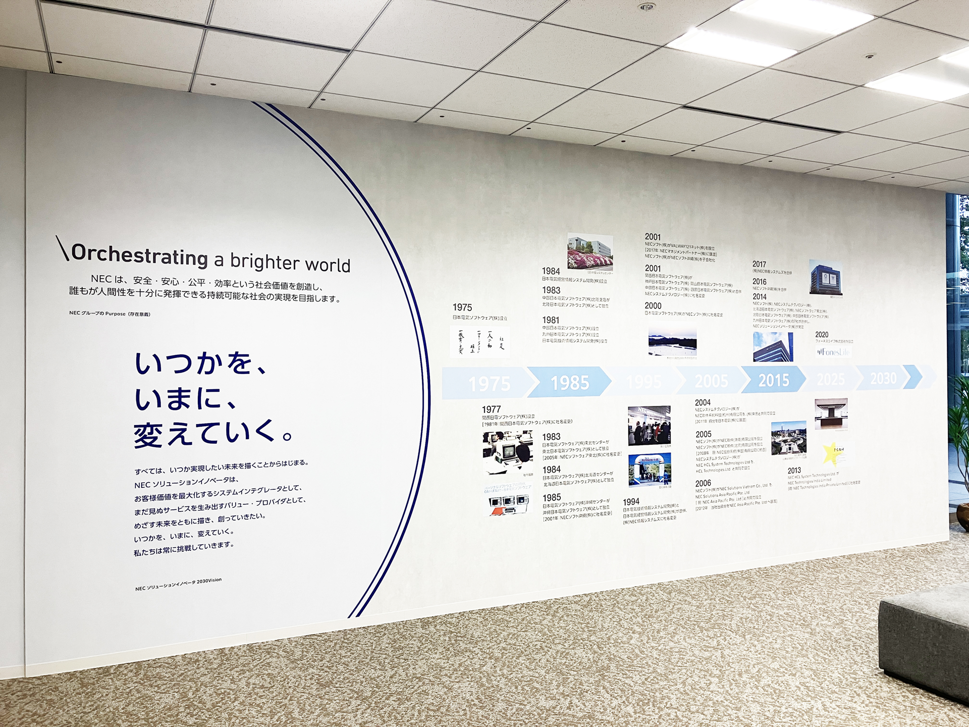 NECのパーパスである「Orchestrating a brighter world」と歴史年表を掲示したオフィス壁面。創立50周年の節目を迎え作成された。